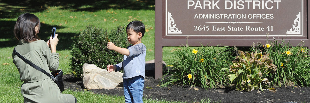 Child in front of park district sign