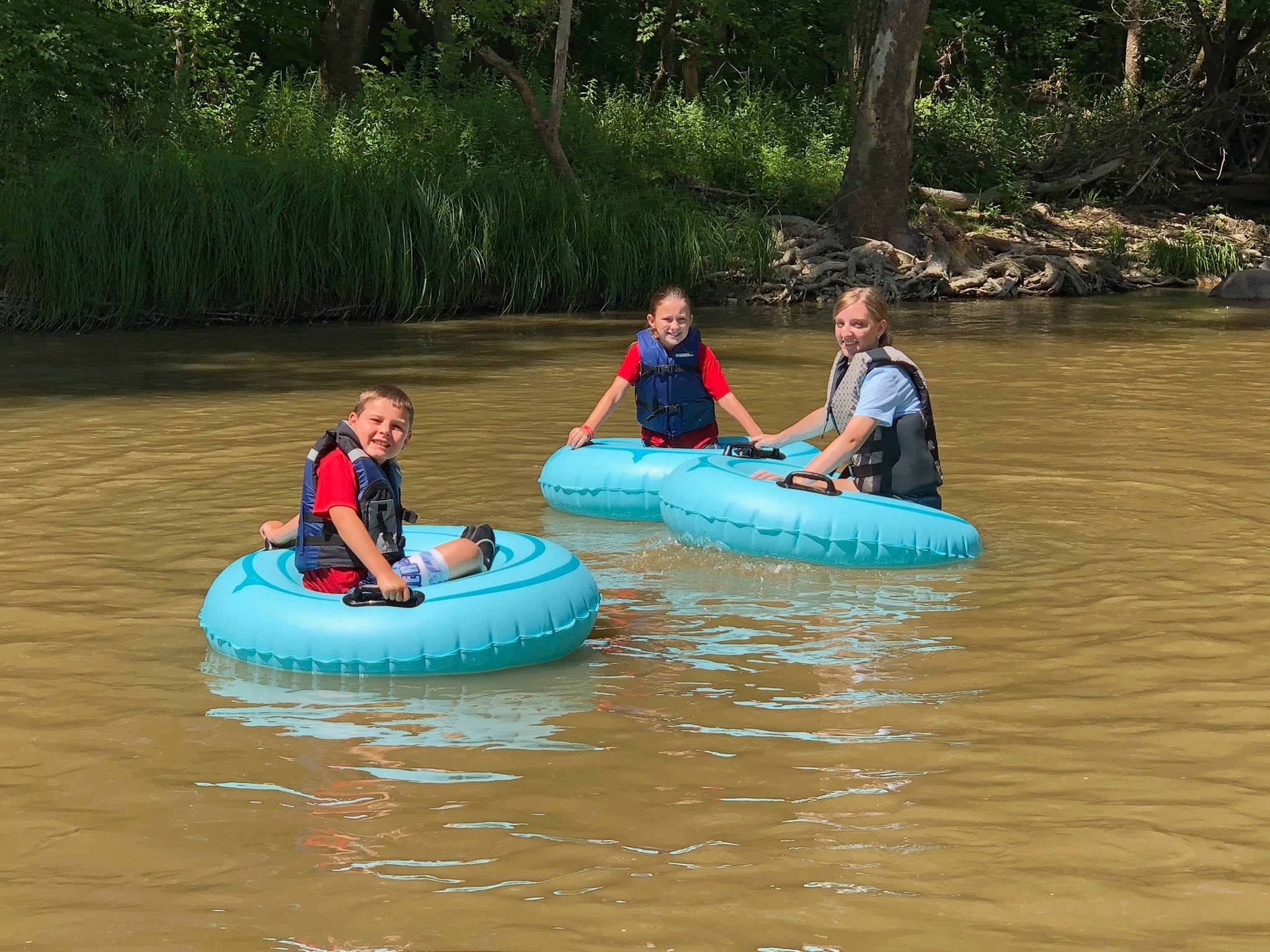 kids riding on inter tubes down the river