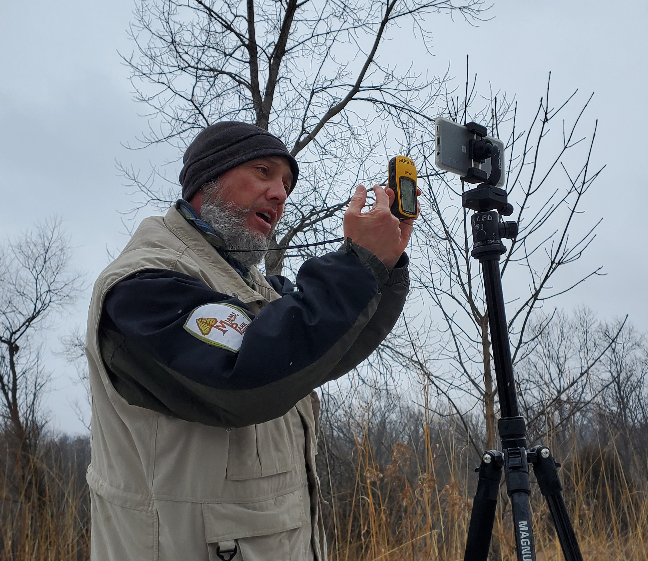 Naturalist holding up a GPS unit to a camera